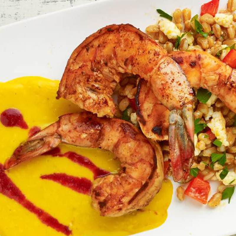 Креветки зі спеціями підсмаженою кукурудзою сливовим пюре та салатом фарро