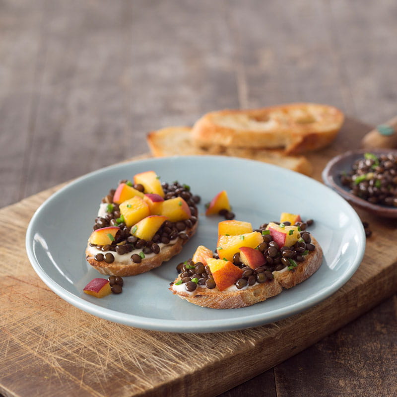 Тости з консервованим персиком та чорною сочевицею